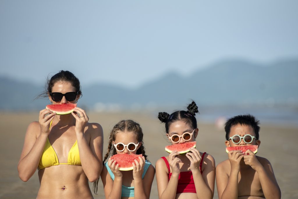 front-view-woman-kids-eating-watermelon